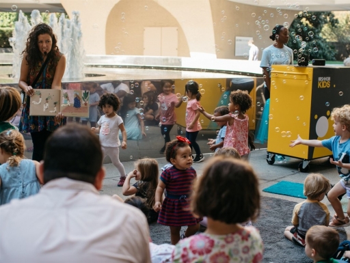 A museum educator instructs a group of young students