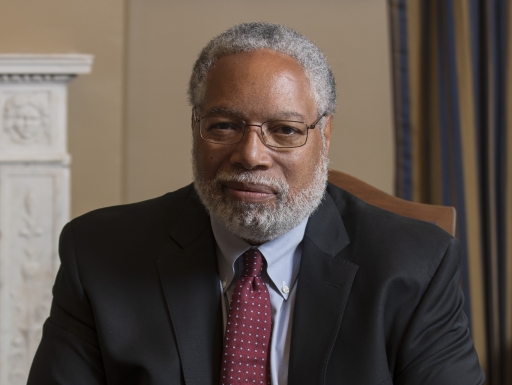 Secretary Lonnie Bunch sits at table with hands folded