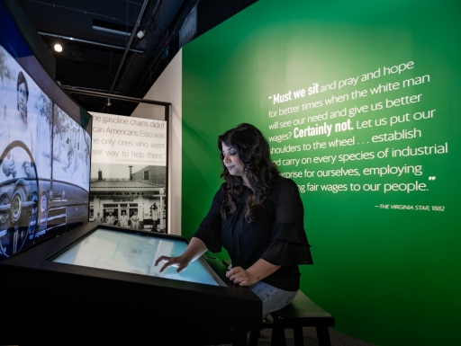 A woman interacts with a screen in an exhibition.