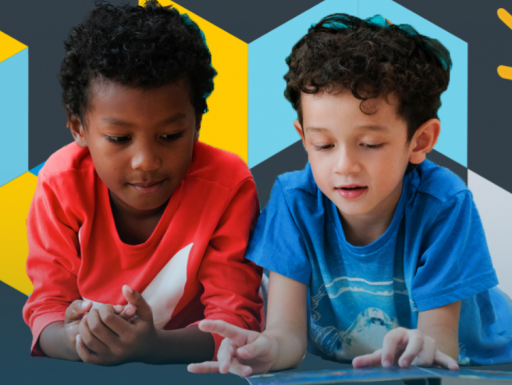 Two young children reading a book together.