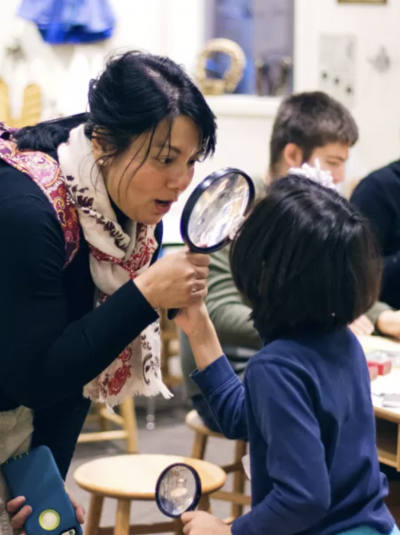 woman and child holding magnifying glasses