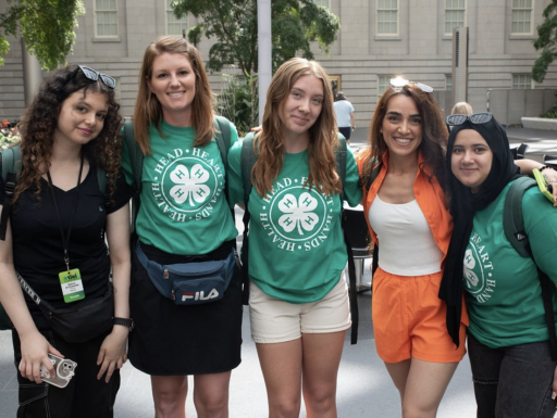 A group of 4H members pose in a museum courtyard.